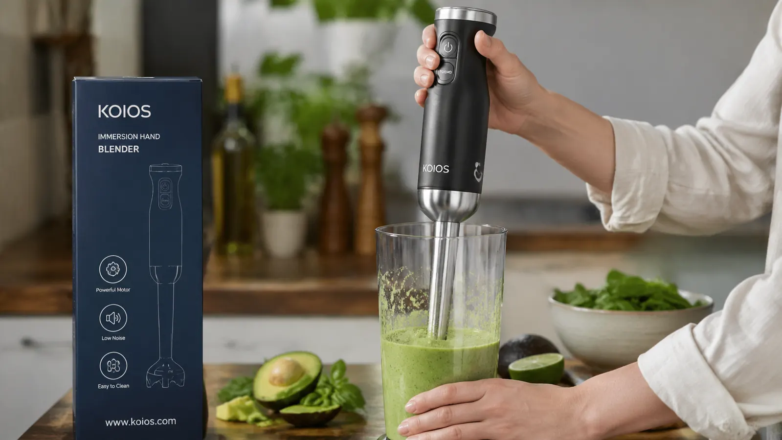 Hand holding the KOIOS immersion blender and submerging it into a beaker of smoothie, close-up in-use shot