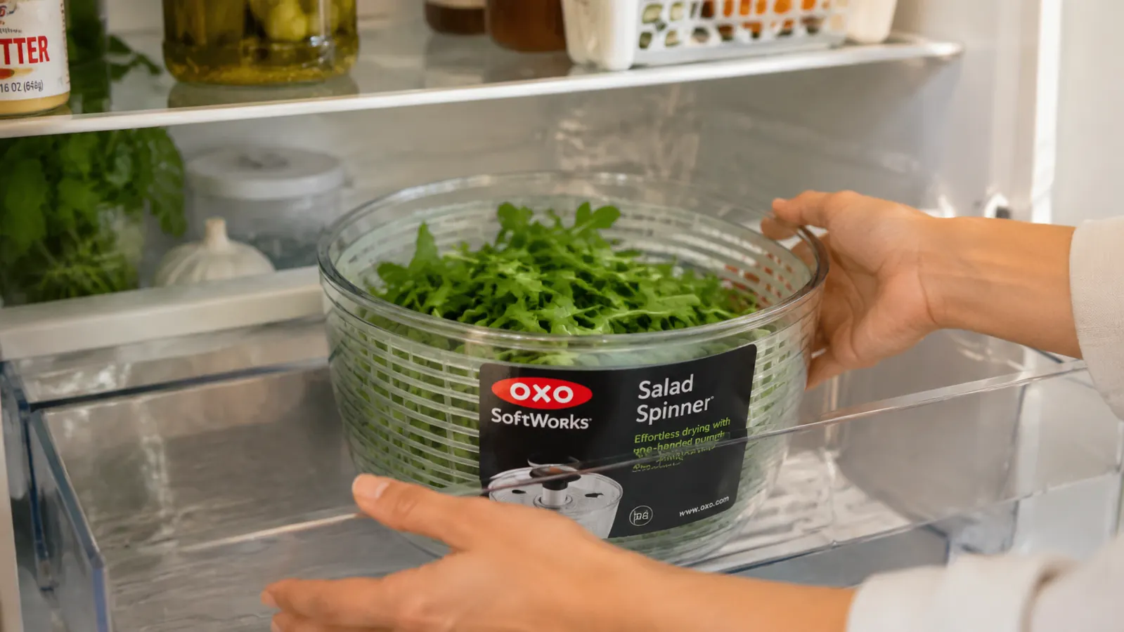 Fresh washed arugula stored inside the OXO salad spinner bowl in a refrigerator drawer